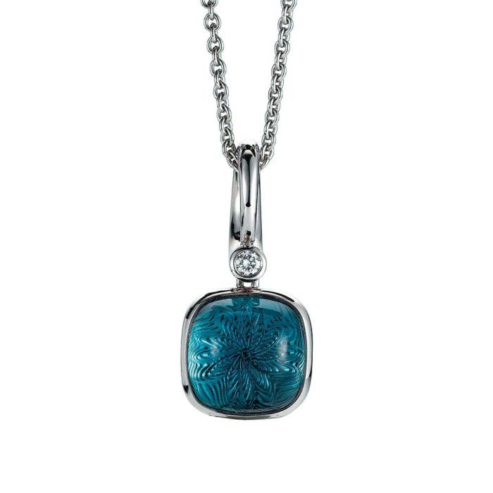 Gold pendant with blue gemstone on guilloched surface with diamond