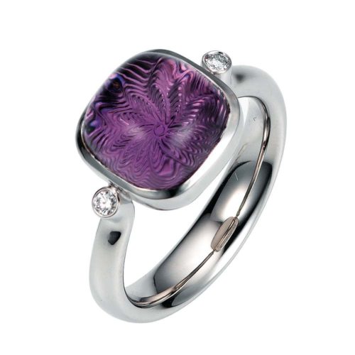 Gold ring with purple gemstone amethyst on guilloched surface with diamonds
