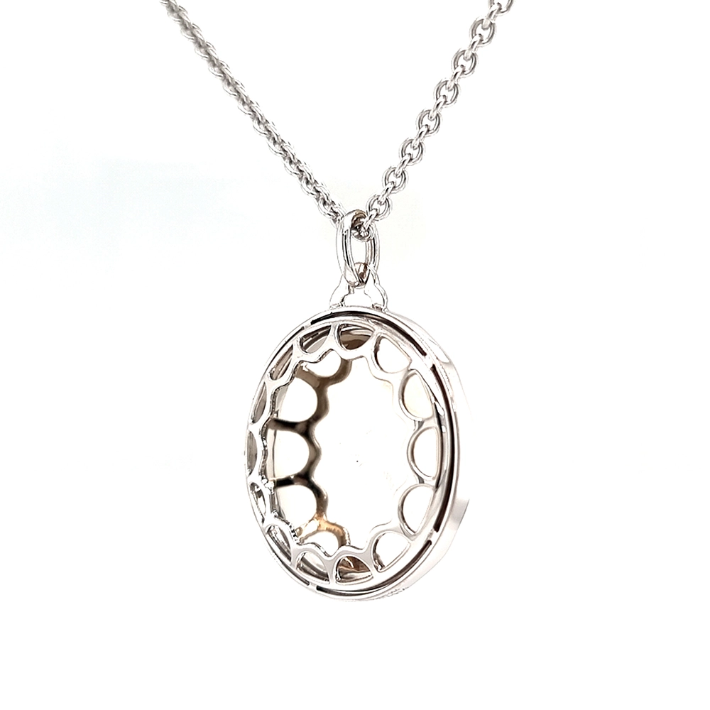 A round pendant on a chain. It is made of white gold and about the size of a large coin. The surface shines in a rich ruby-red colour with a wavy pattern. Across it runs a large flower shape made of many small diamonds. The pendant hangs from a fine chain.