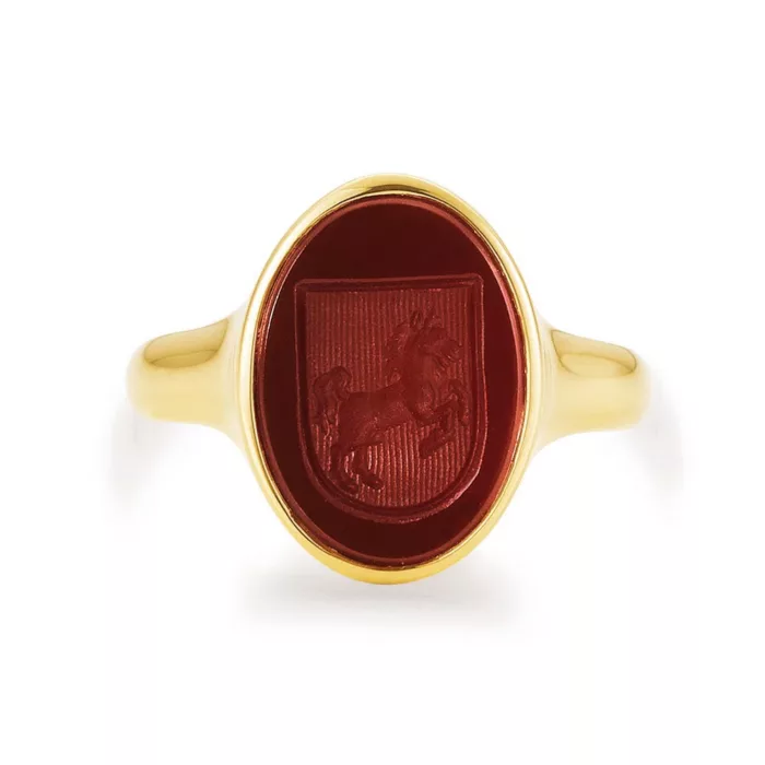 Signet ring yellow gold with red oval gemstone with engraved shield on it a horse.