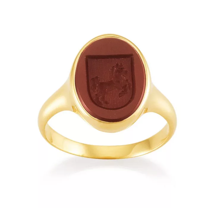 Signet ring yellow gold with red oval gemstone with engraved shield on it a horse. Front view.
