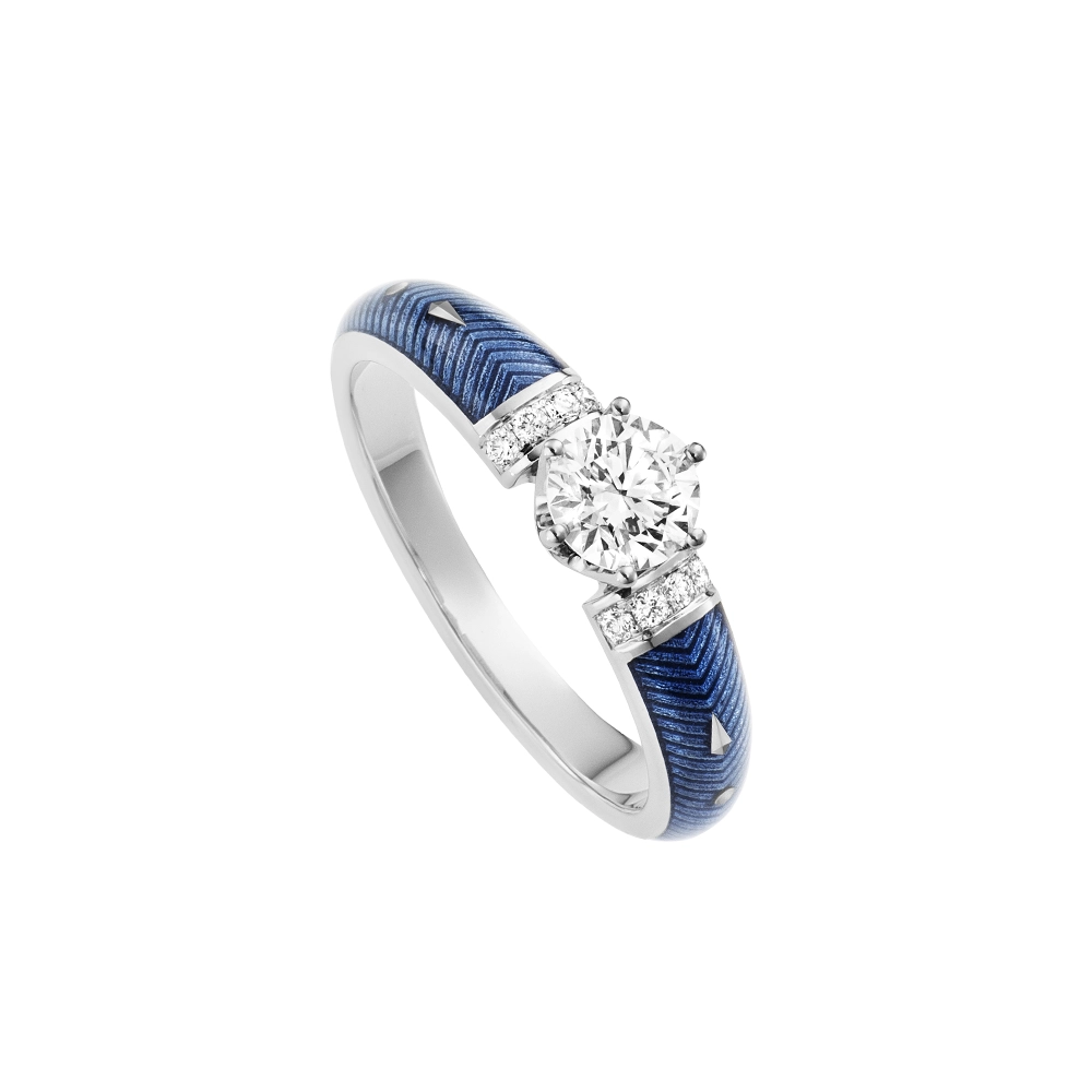 Golden ring with a white centre stone and two rows of small diamonds next to it. The ring shoulders are coloured light blue.