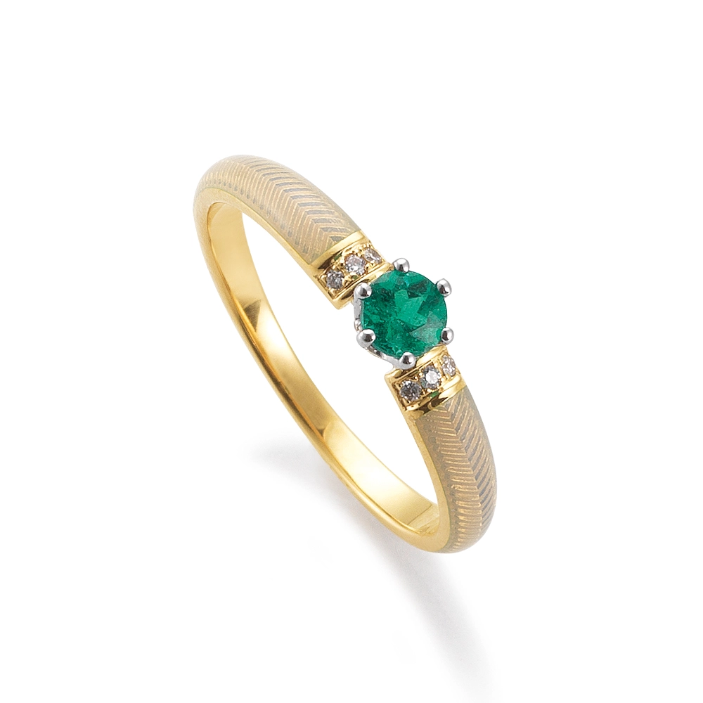 Golden ring with a green centre stone and two rows of small diamonds next to it. The ring shoulders are coloured white.