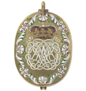 Oval gold pendant with painting of a crown stylized initials and wiht aframe of floral patters in white, green and purple enamels. 