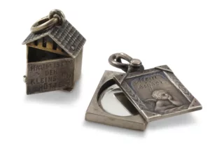 Silver pendant in the shpae of a tiny house with an opening door and a locket shaped like a rectangular photograph frame with inscription "my sweet" and a little angel with on the bottom which slid open to reveal a mirror. 