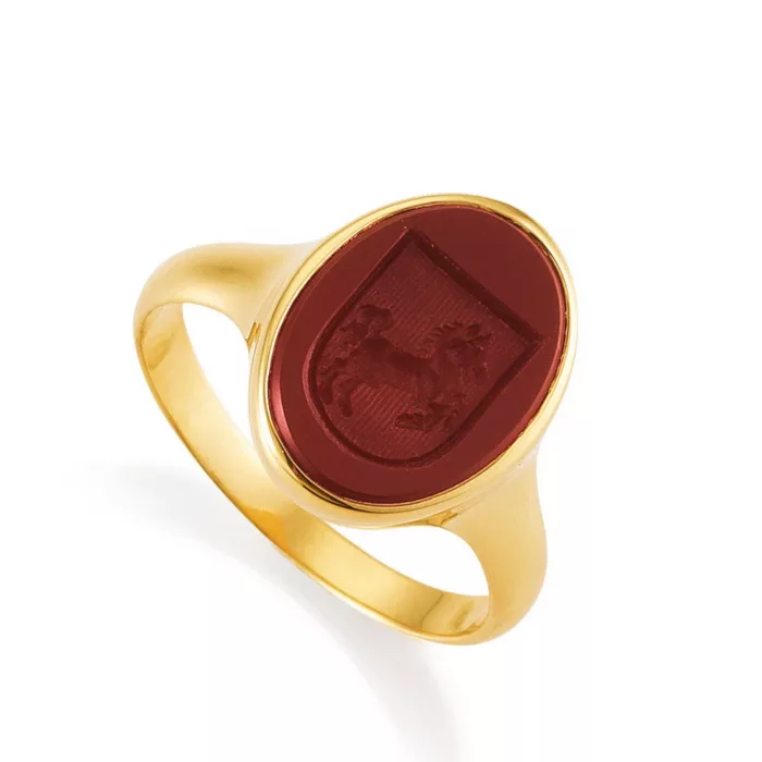 Signet ring yellow gold with red oval gemstone with engraved shield on it a horse. Side view from left