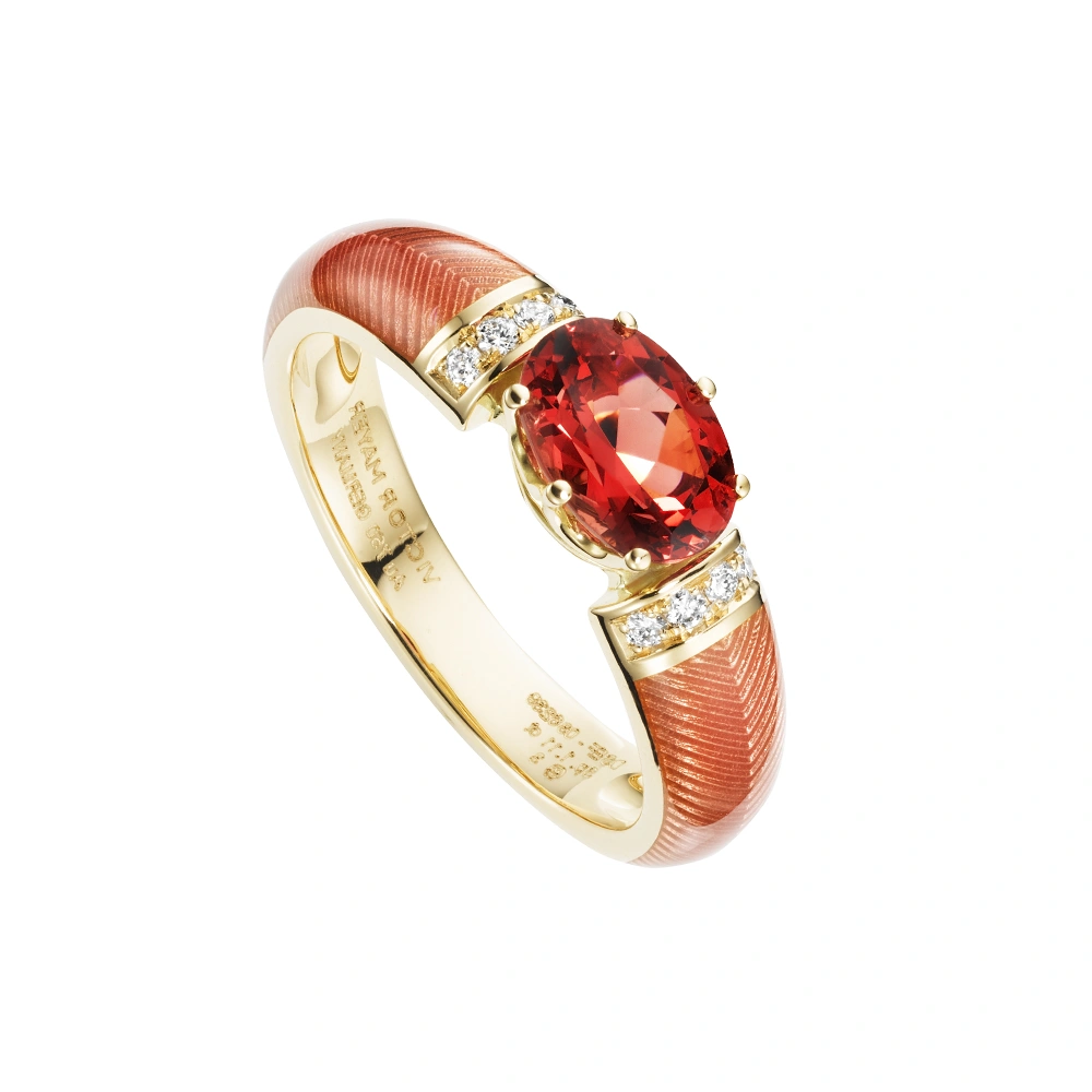 Golden ring with a oval pink stone and two rows of small diamonds next to it. The ring shoulders are coloured pink.