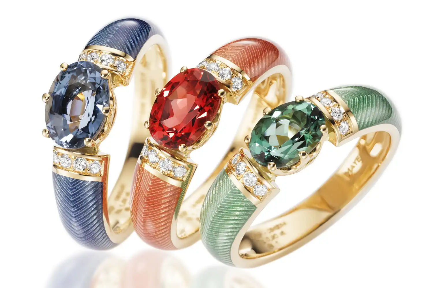 Three gold rings with colourful oval gemstones, each ring with two stripes of small white diamonds. The rings are covered in transparent colour, under which a fine thread pattern is visible,1500x1000. Horizontal pictur.