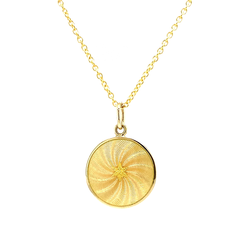 Small round pendant made of yellow gold, about the size of a small coin. The front shimmers in golden yellow translucent enamel with a fine wave pattern. At the center lies a tiny hexagonal gold insert shaped as a star with microscopic relief details.