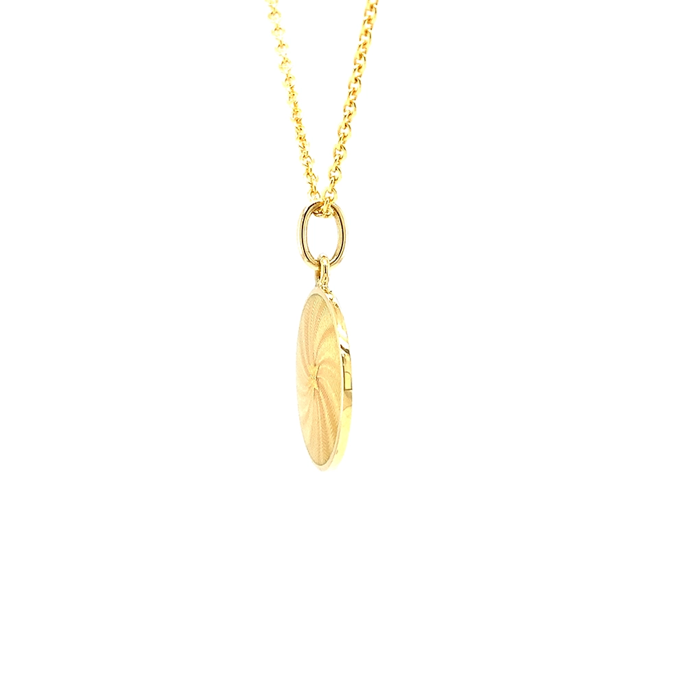 Small round pendant made of yellow gold, about the size of a small coin. The front shimmers in golden yellow translucent enamel with a fine wave pattern. At the center lies a tiny hexagonal gold insert shaped as a star with microscopic relief details.