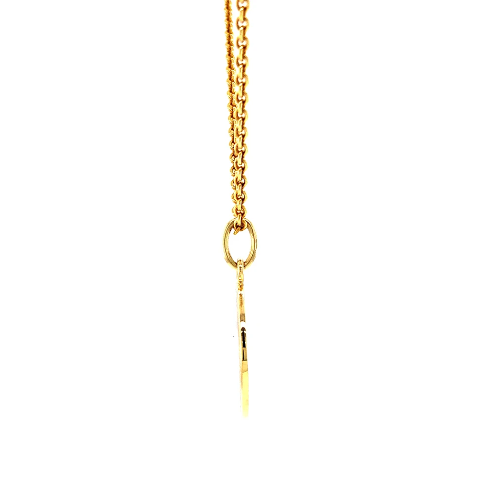 Kleiner runder Anhänger aus Gelbgold, etwa so groß wie eine kleine Münze. Die Vorderseite schimmert in transluzider herbstgelber Emaille mit feinem Wellenmuster. In der Mitte liegt ein winziges sechseckiges Goldplättchen in Sternform mit mikroskopisch feinen Reliefdetails.