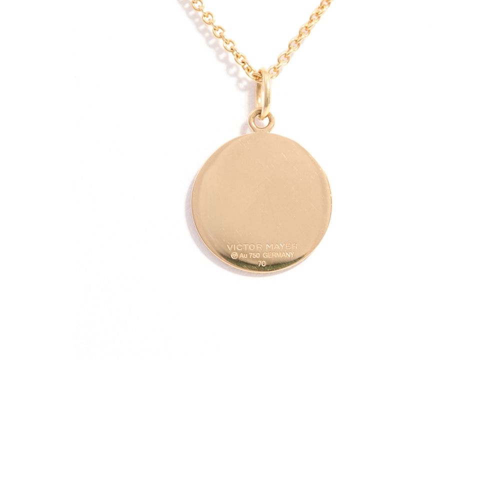 Small round pendant made of yellow gold, about the size of a small coin. The front shimmers in pink translucent enamel with a fine wave pattern. At the center lies a tiny hexagonal gold insert shaped as a star with microscopic relief details.