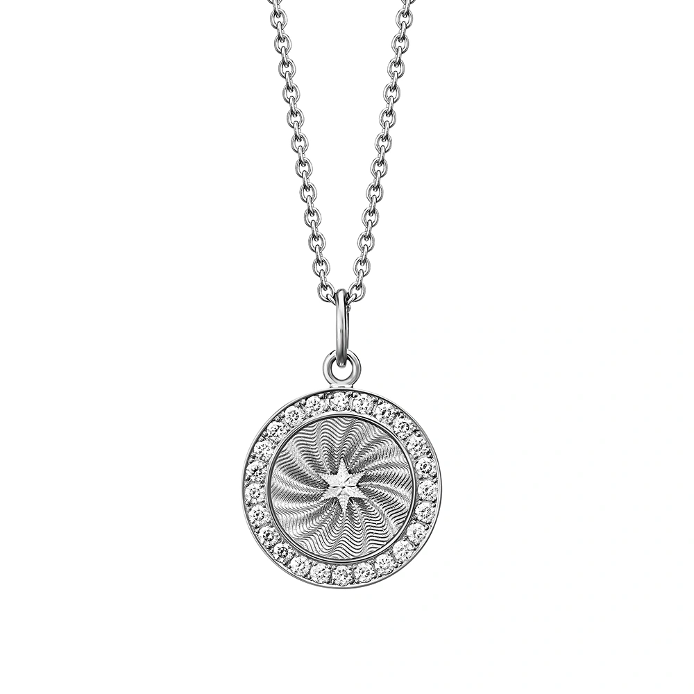 Small round pendant made of white gold, about the size of a small coin. The front shimmers silver-grey in translucent enamel with a fine wave pattern. At the center lies a tiny hexagonal star-shaped gold insert, surrounded by 24 sparkling diamonds.