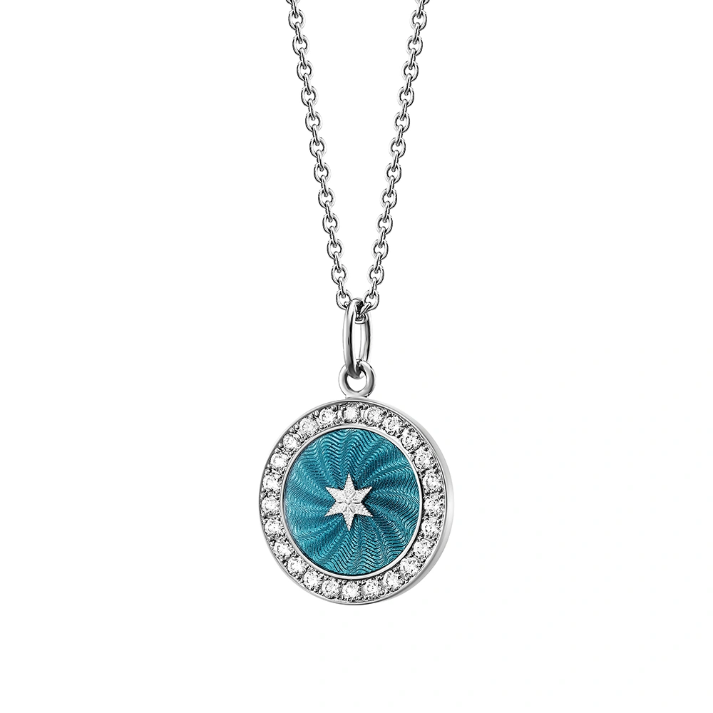 Small round pendant made of white gold, about the size of a small coin. The front shimmers turquoise in translucent enamel with a fine wave pattern. At the center lies a tiny hexagonal star-shaped gold insert, surrounded by 24 sparkling diamonds.