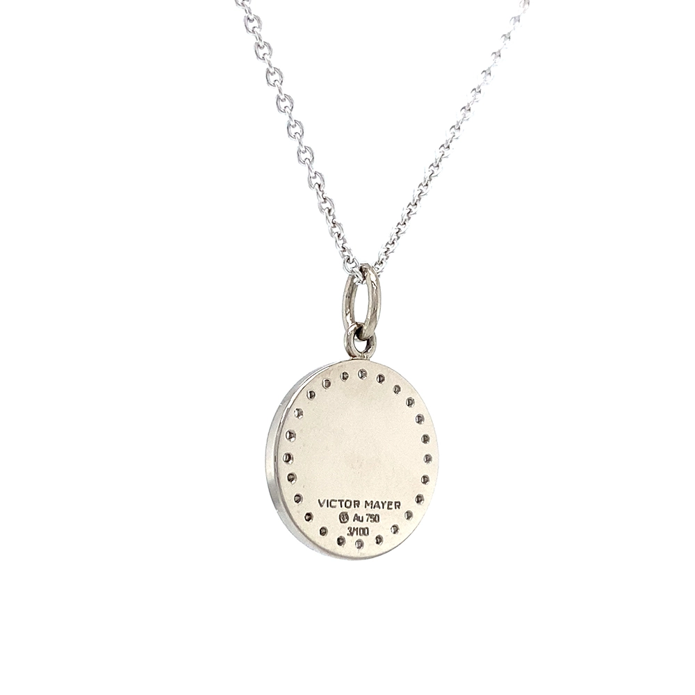 Small round pendant made of white gold, about the size of a small coin. The front shimmers turquoise in translucent enamel with a fine wave pattern. At the center lies a tiny hexagonal star-shaped gold insert, surrounded by 24 sparkling diamonds.