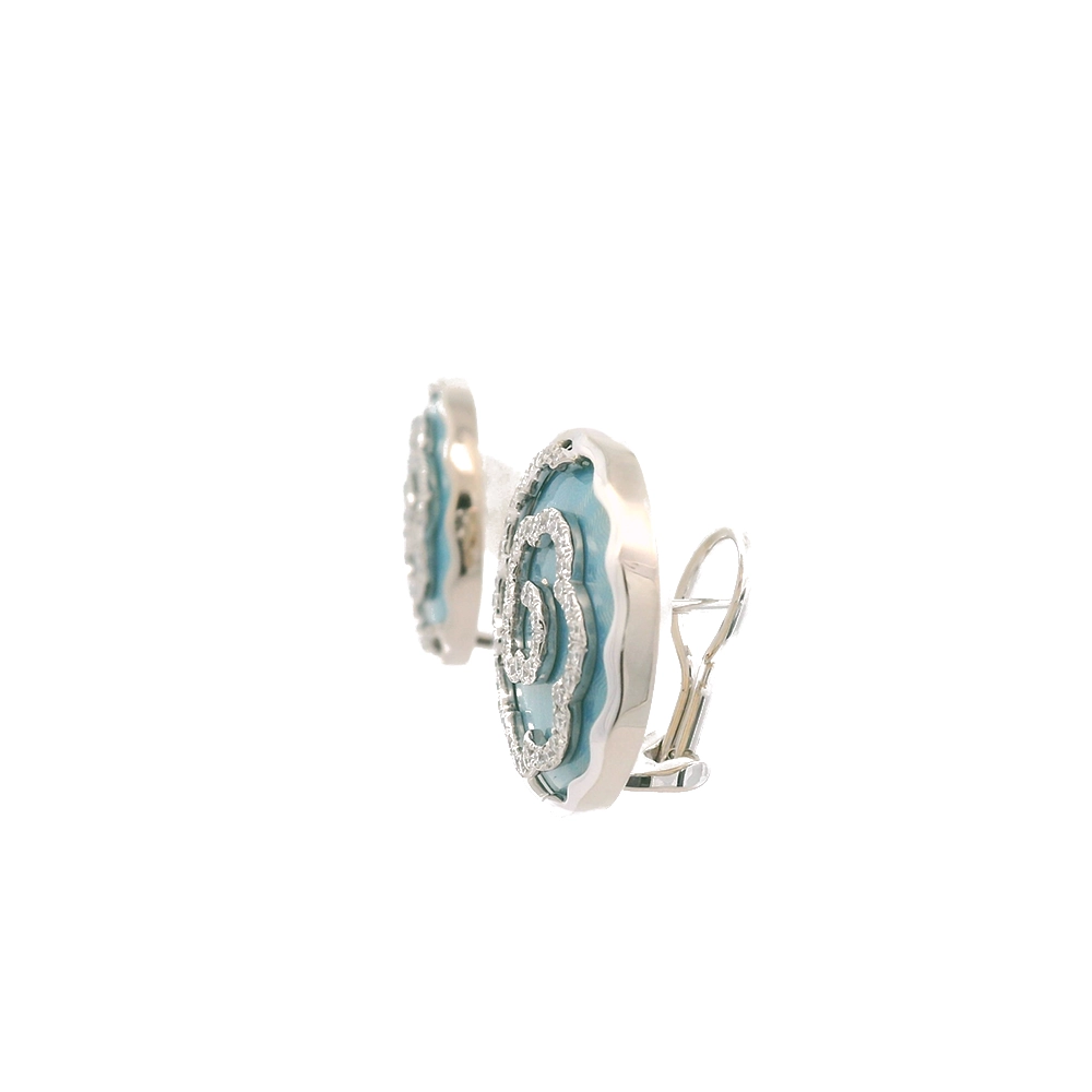Ein Paar runde Ohrringe aus Weißgold. Der Ohrschmuck hat etwa die Größe einer Münze. Die Oberfläche schimmert in einem kräftigen Opal-Türkis-Ton mit einem wellenartigen Muster. Darüber liegt die Form einer großen Blüte, besetzt mit vielen kleinen Diamanten.