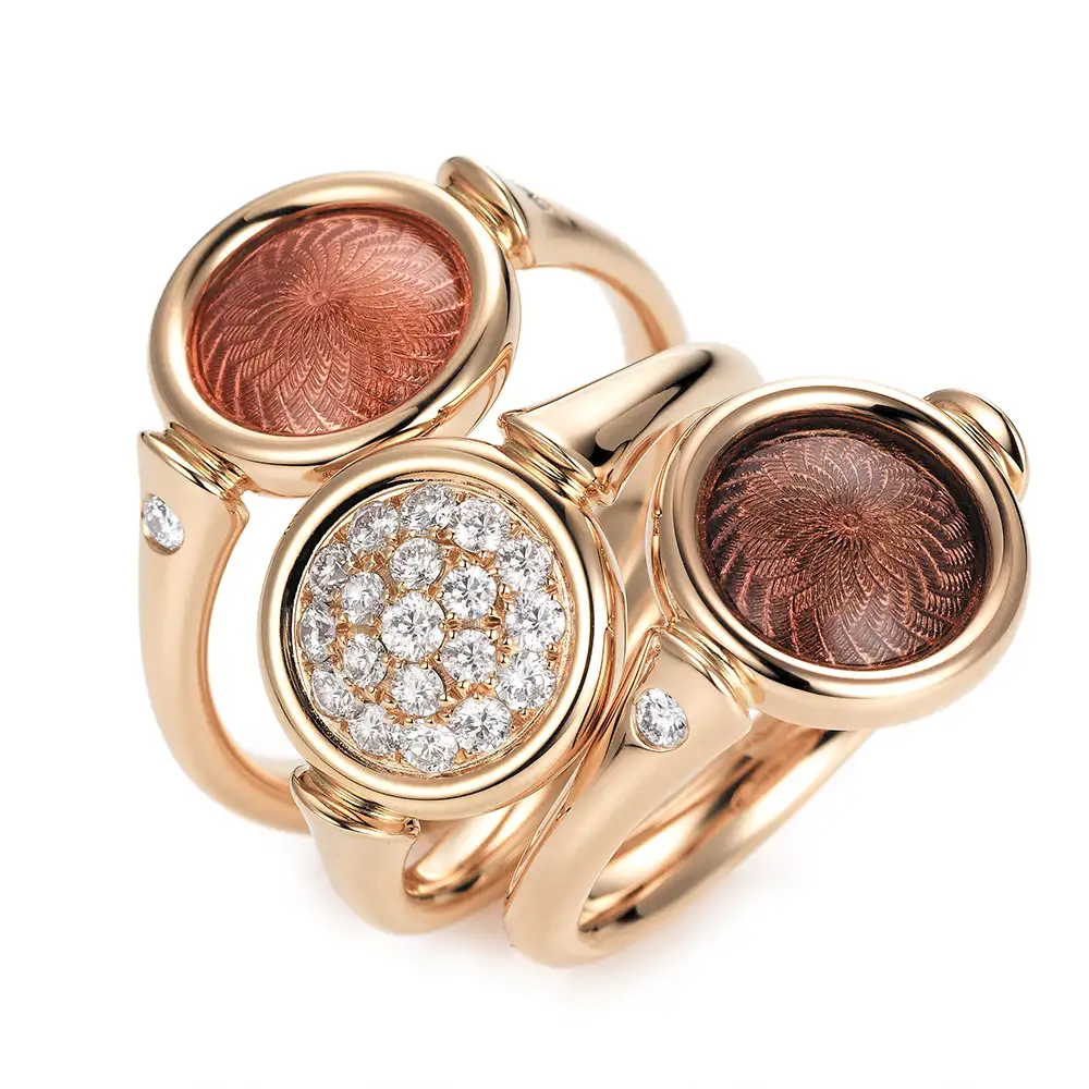 Schmuckset Candy in Roségold, zwei Ringe mit rundem, leicht gewölbtem Kopf, violetter und rosa Emaille in Windmühlenmuster und ein Ring mit Diamantpavé, alle mit einem Durchmesser von 11 mm.