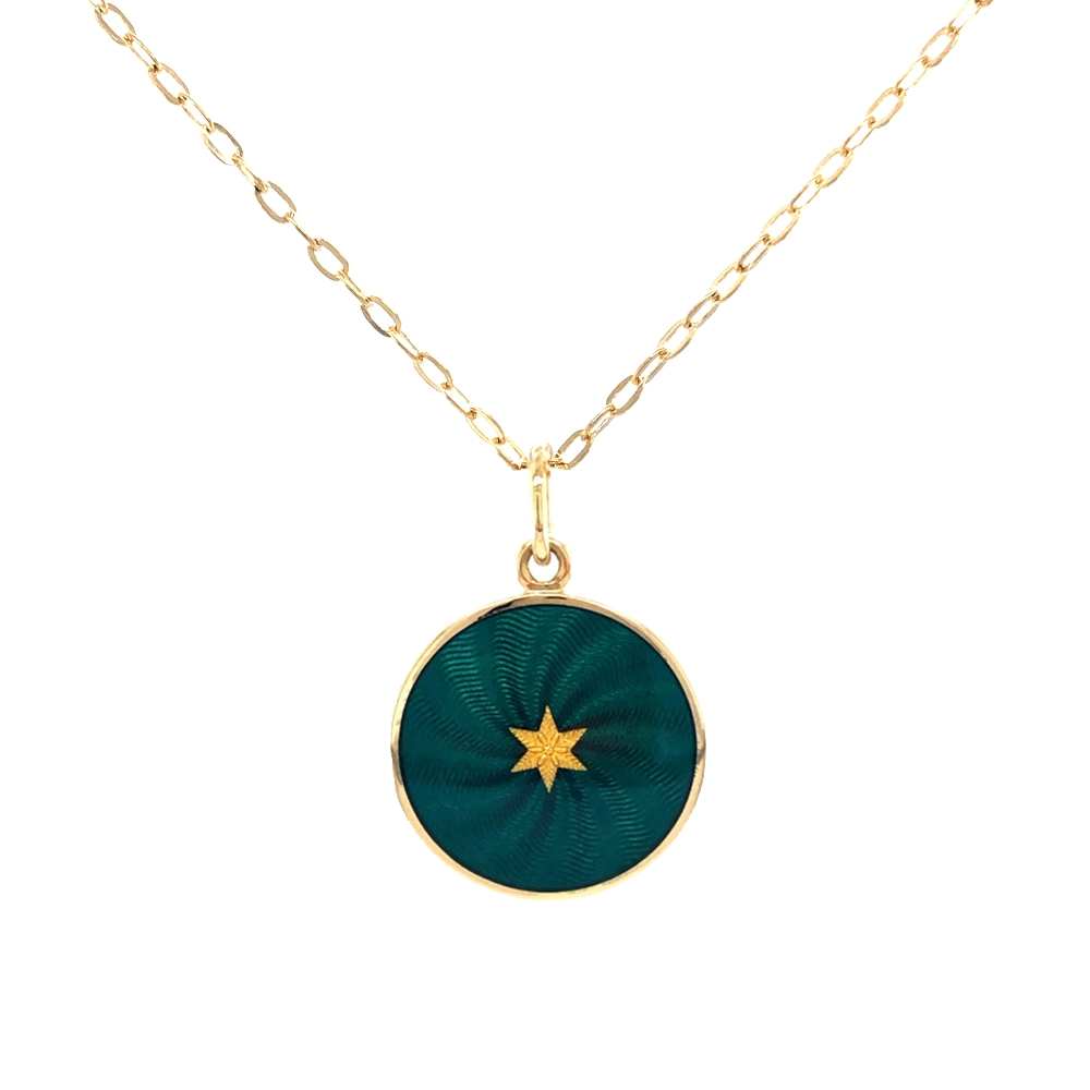 Small round pendant made of yellow gold, about the size of a small coin. The front shimmers in emerald green translucent enamel with a fine wave pattern. At the center lies a tiny hexagonal gold insert shaped as a star with microscopic relief details.
