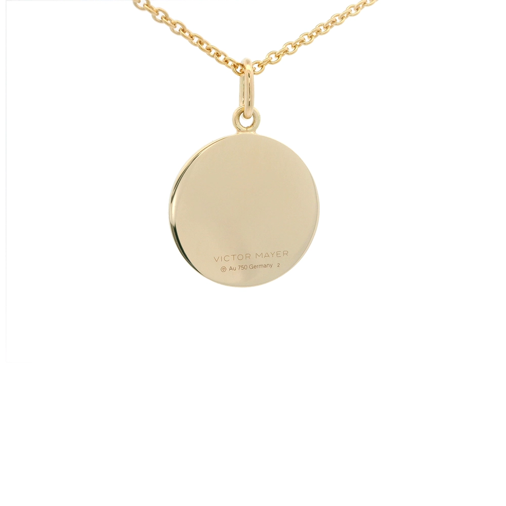 Kleiner runder Anhänger aus Gelbgold, etwa so groß wie eine kleine Münze. Die Vorderseite schimmert mediumblau in durchscheinender Emaille mit feinem Wellenmuster. In der Mitte ist ein winziges sechseckiges Goldplättchen eingelassen, das die Buchstaben V und M als Relief zeigt.