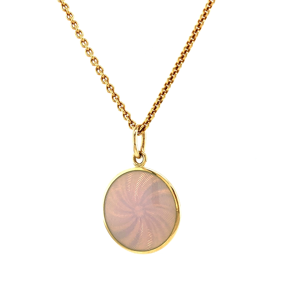 Small round pendant made of yellow gold, about the size of a small coin. The front shimmers in opalescent white, shifting colours like an opal when catching the light. A fine wave pattern appears beneath the enamel.