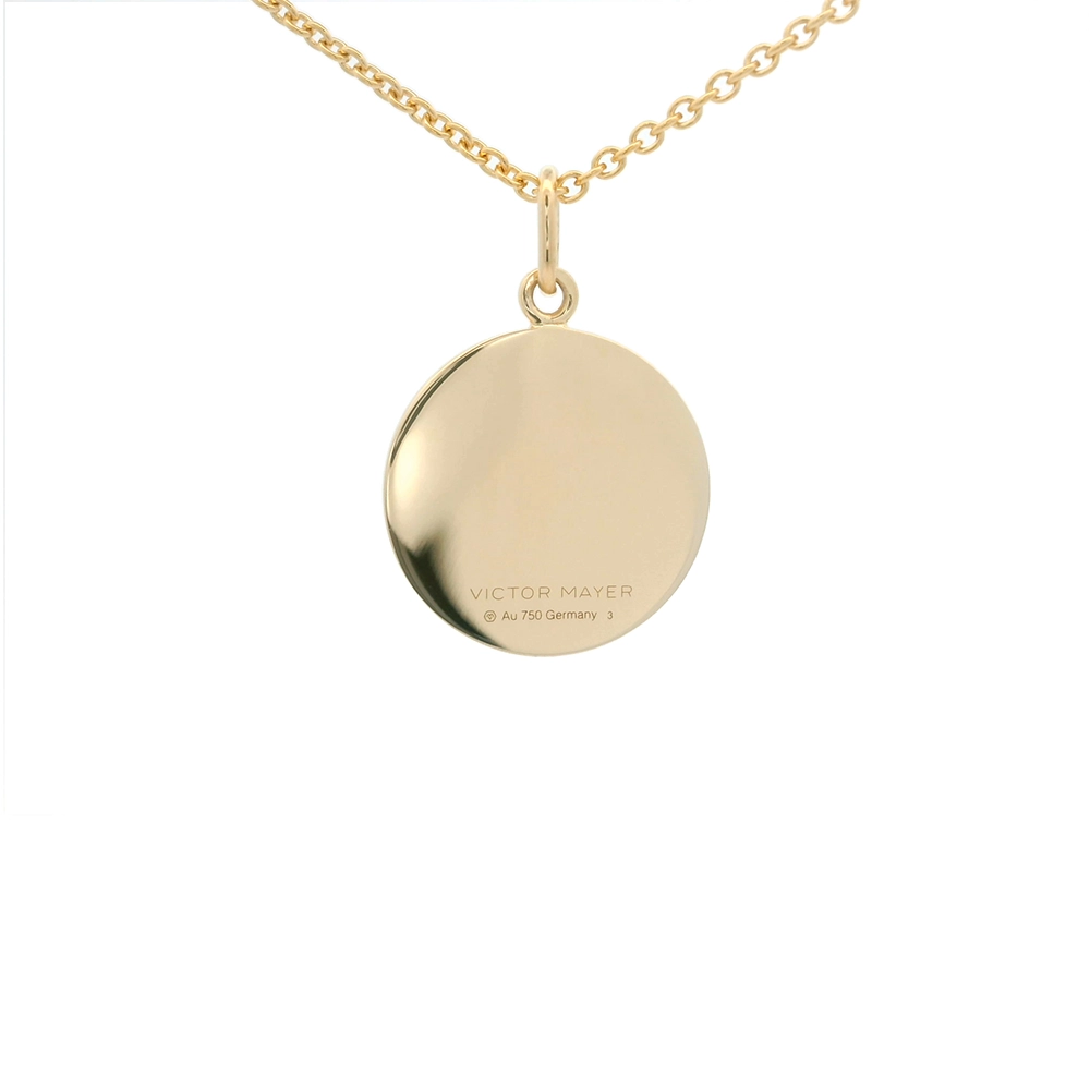 Kleiner runder Anhänger aus Gelbgold, etwa so groß wie eine kleine Münze. Die Vorderseite schimmert rosa in durchscheinender Emaille mit feinem Wellenmuster. In der Mitte ist ein winziges sechseckiges Goldplättchen eingelassen, das die Buchstaben V und M als Relief zeigt.