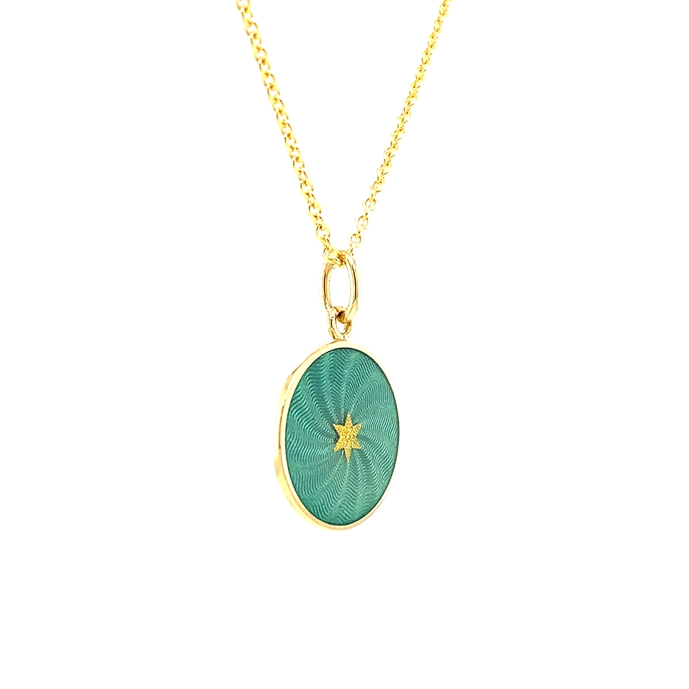 Small round pendant made of yellow gold, about the size of a small coin. The front shimmers in turquoise translucent enamel with a fine wave pattern. At the center lies a tiny hexagonal gold insert shaped as a star with microscopic relief details.