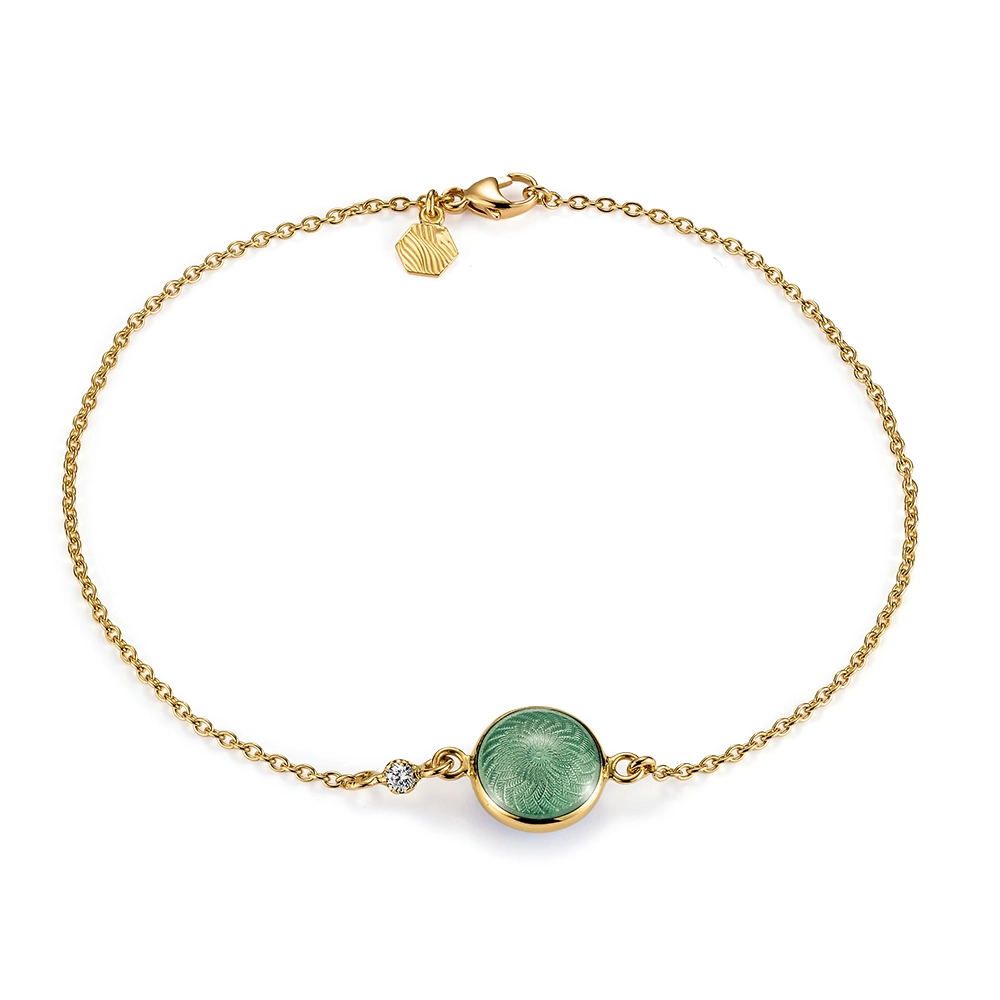 Rundes Armband Candy aus Gelbgold mit beidseitig emaillierter, helltürkisfarbener Feueremaille über Windmühlen-Guilloché, funkelndem Brillant in der Ankerkette und guillochiertem Sechseck-Plättchen am Verschluss, Durchmesser 20,2 mm, Länge 19 cm.