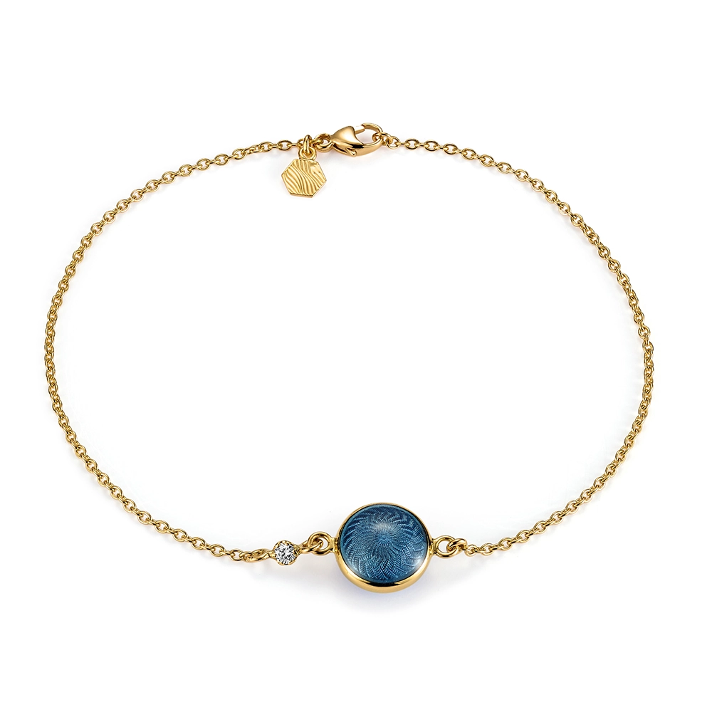 Rundes Armband Candy aus Gelbgold mit beidseitig emaillierter, mediumblauer Feueremaille über Windmühlen-Guilloché, funkelndem Brillant in der Ankerkette und guillochiertem Sechseck-Plättchen am Verschluss, Durchmesser 20,2 mm, Länge 19 cm.