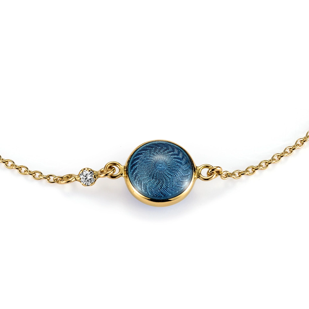 Rundes Armband Candy aus Gelbgold mit beidseitig emaillierter, mediumblauer Feueremaille über Windmühlen-Guilloché, funkelndem Brillant in der Ankerkette und guillochiertem Sechseck-Plättchen am Verschluss, Durchmesser 20,2 mm, Länge 19 cm.