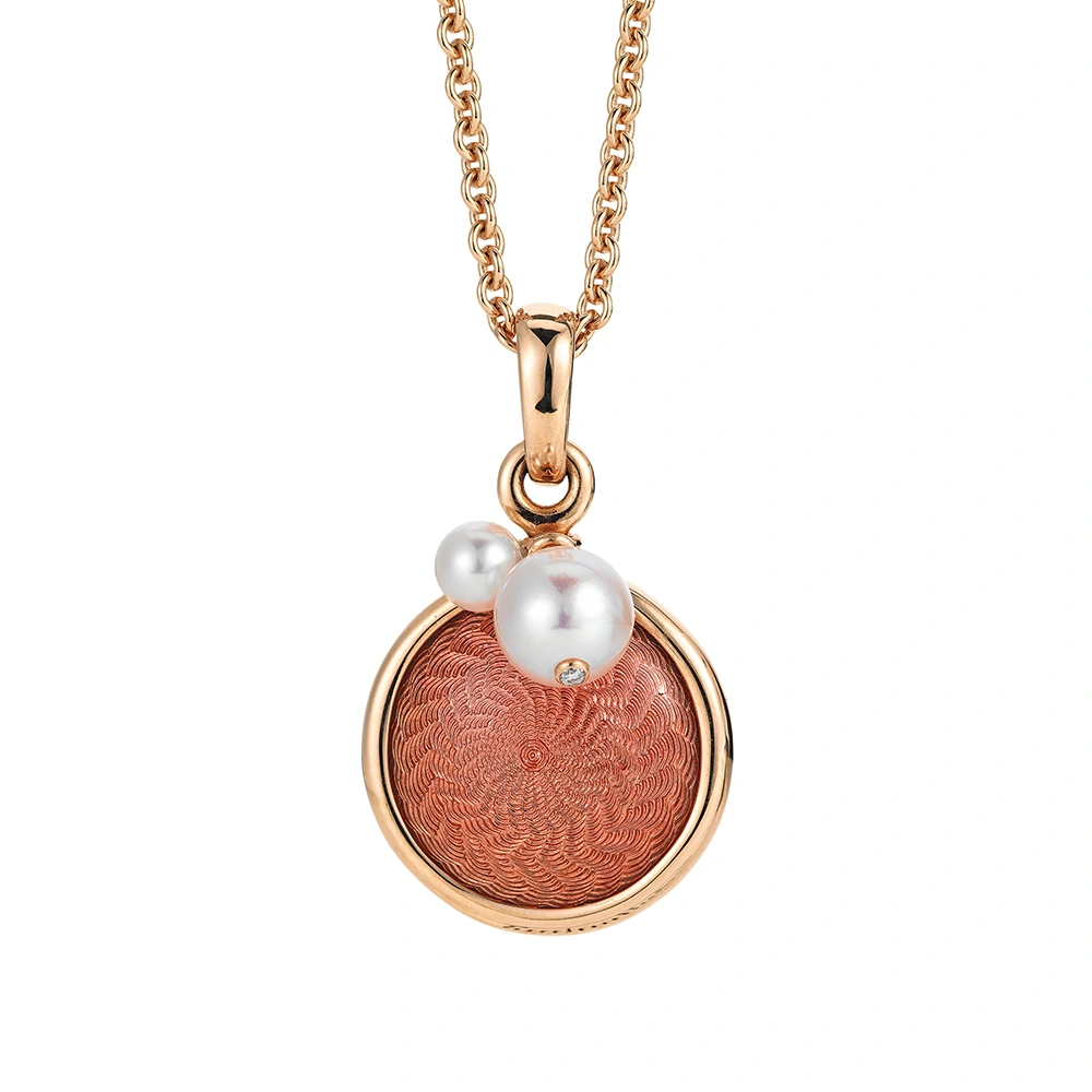 Anhänger Candy aus Roségold mit rundem, leicht gewölbtem Mittelteil, rosafarbener Feueremaille im Windmühlenmuster, 1 Brillant und 2 Akoya Zuchtperlen, Durchmesser 17,6 mm.