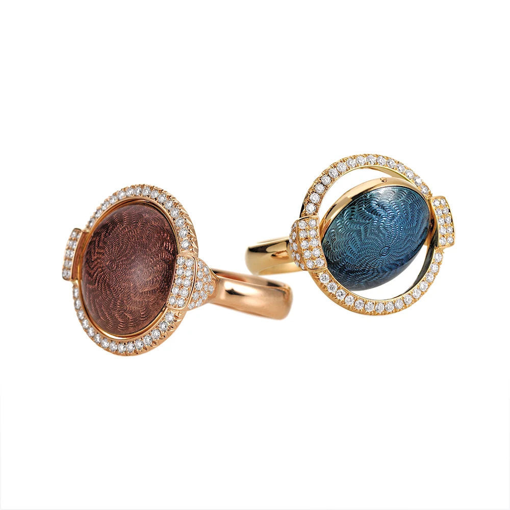 Swivel rings Candy in gold with a round domed centre lens that can be turned to show pink or purple enamel in one ring and medium blue and light turquoise in the other, decorated with a windmill guilloché pattern and framed with 78 diamonds, 20 x 22 mm.