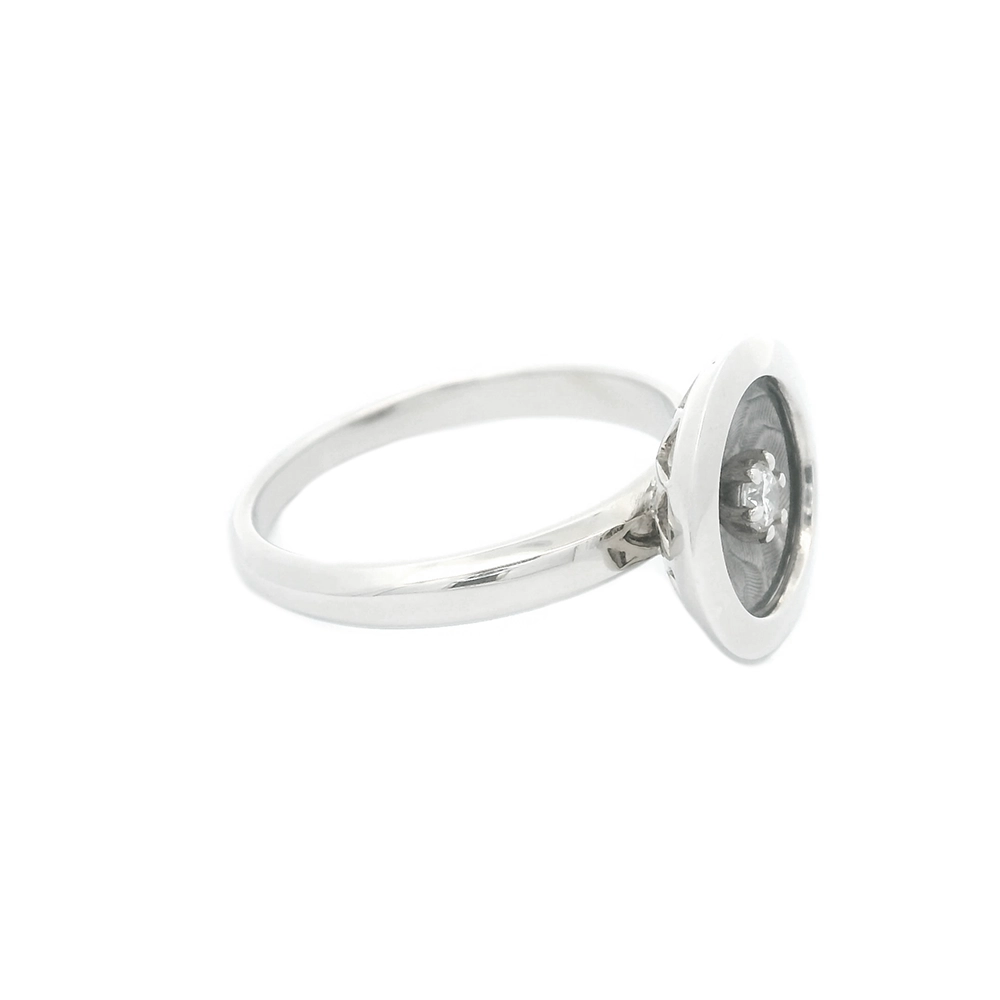 Ring in white gold with a round ring head. The ring head is concave and covered with translucent tahiti-grey vitreous enamel, beneath which a fine windmill guilloché pattern is visible. A single small diamond is set at the centre of the enamel surface as a subtle focal point. The design appears calm, geometric, and balanced.