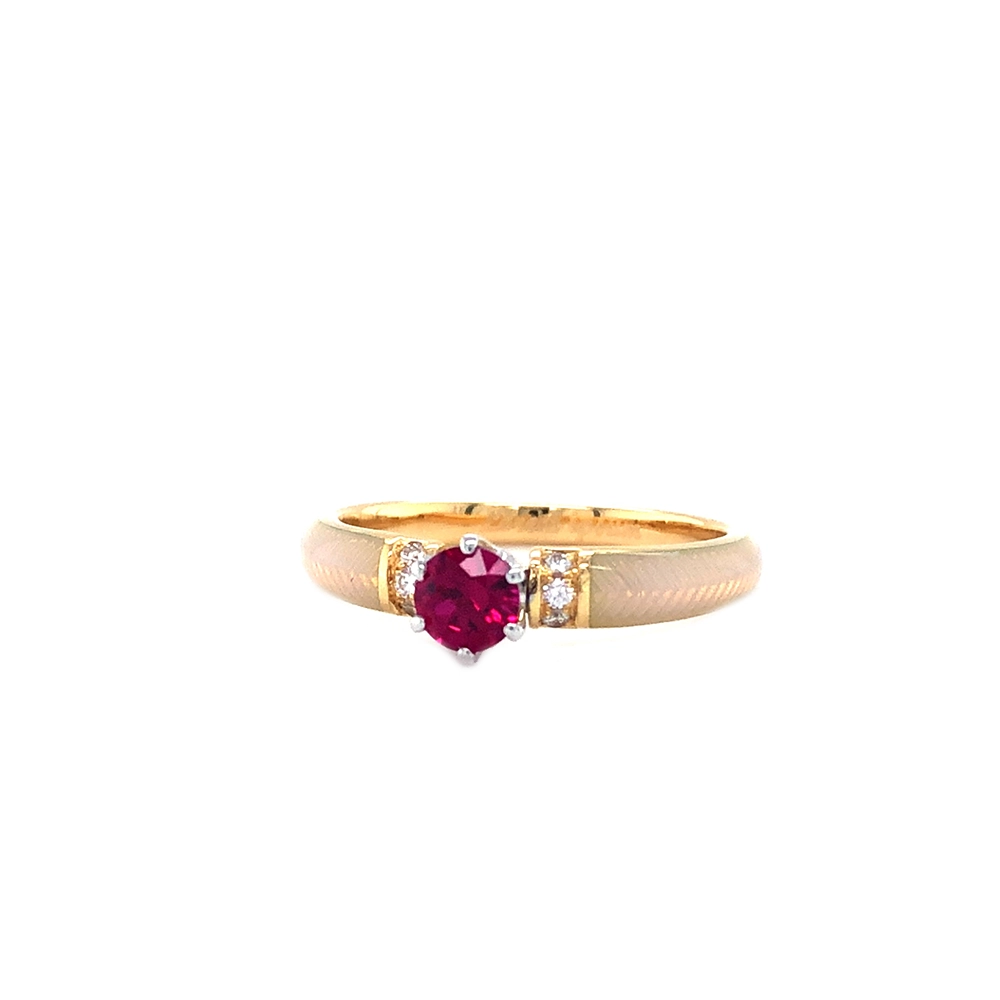 Goldener Ring mit einem roten Mittelstein und zwei Reihen kleiner Diamanten daneben. Die Ringschultern sind weiß gefärbt.