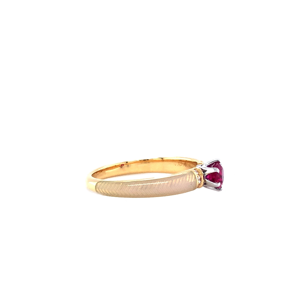 Goldener Ring mit einem roten Mittelstein und zwei Reihen kleiner Diamanten daneben. Die Ringschultern sind weiß gefärbt.