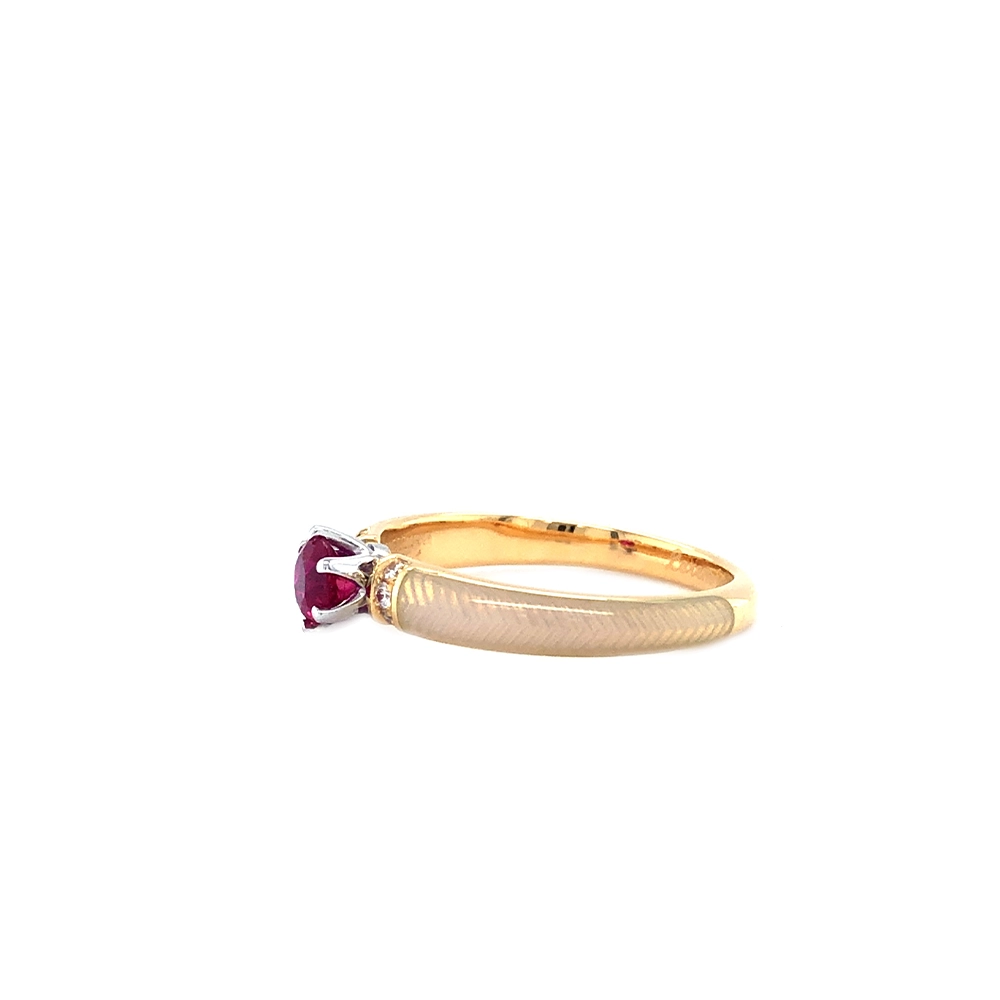 Goldener Ring mit einem roten Mittelstein und zwei Reihen kleiner Diamanten daneben. Die Ringschultern sind weiß gefärbt.