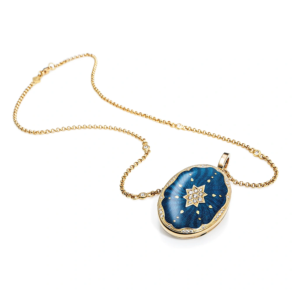 Ovaler Medaillon-Anhänger aus Gelbgold, blau lackiert mit einer vielzahl kleiner goldener Punkte und mit einem Stern aus Brillanten in der Mitte.