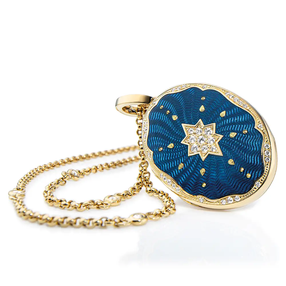 Ovaler Medaillon-Anhänger aus Gelbgold, blau lackiert mit einer vielzahl kleiner goldener Punkte und mit einem Stern aus Brillanten in der Mitte.