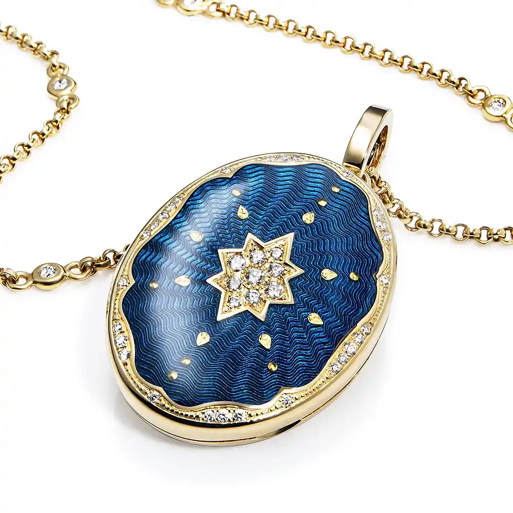 Ovaler Medaillon-Anhänger aus Gelbgold, blau lackiert mit einer vielzahl kleiner goldener Punkte und mit einem Stern aus Brillanten in der Mitte.