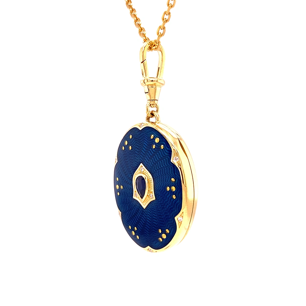 Ovaler Medaillon-Anhänger aus Gelbgold, blau lackiert mit zahlreichen kleinen Goldpunkten und mit einem tropfenförmigen blauen Edelstein in der Mitte.