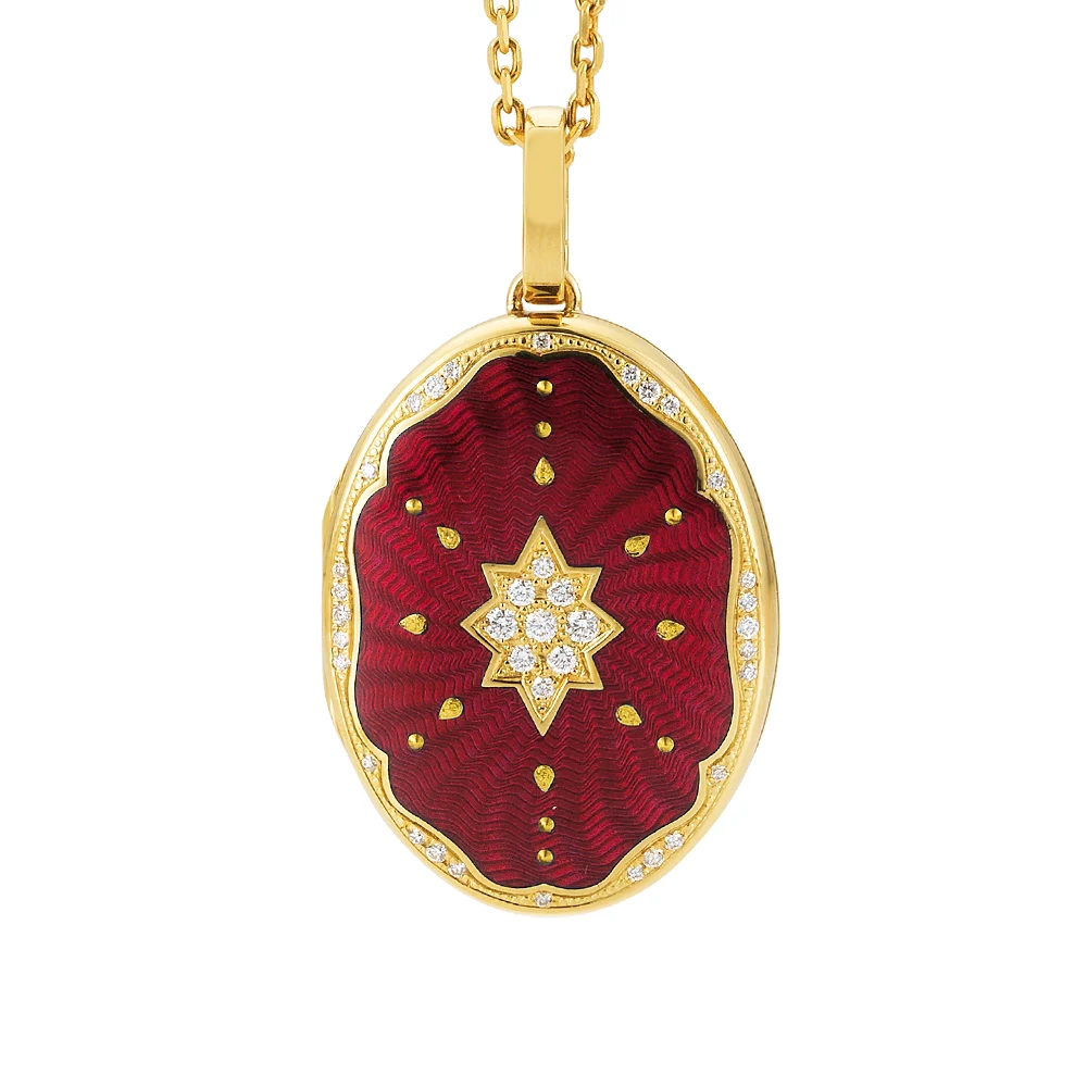Ovaler Medaillon-Anhänger aus Gelbgold, rot lackiert mit einer vielzahl kleiner goldener Punkte und mit einem Stern aus Brillanten in der Mitte.
