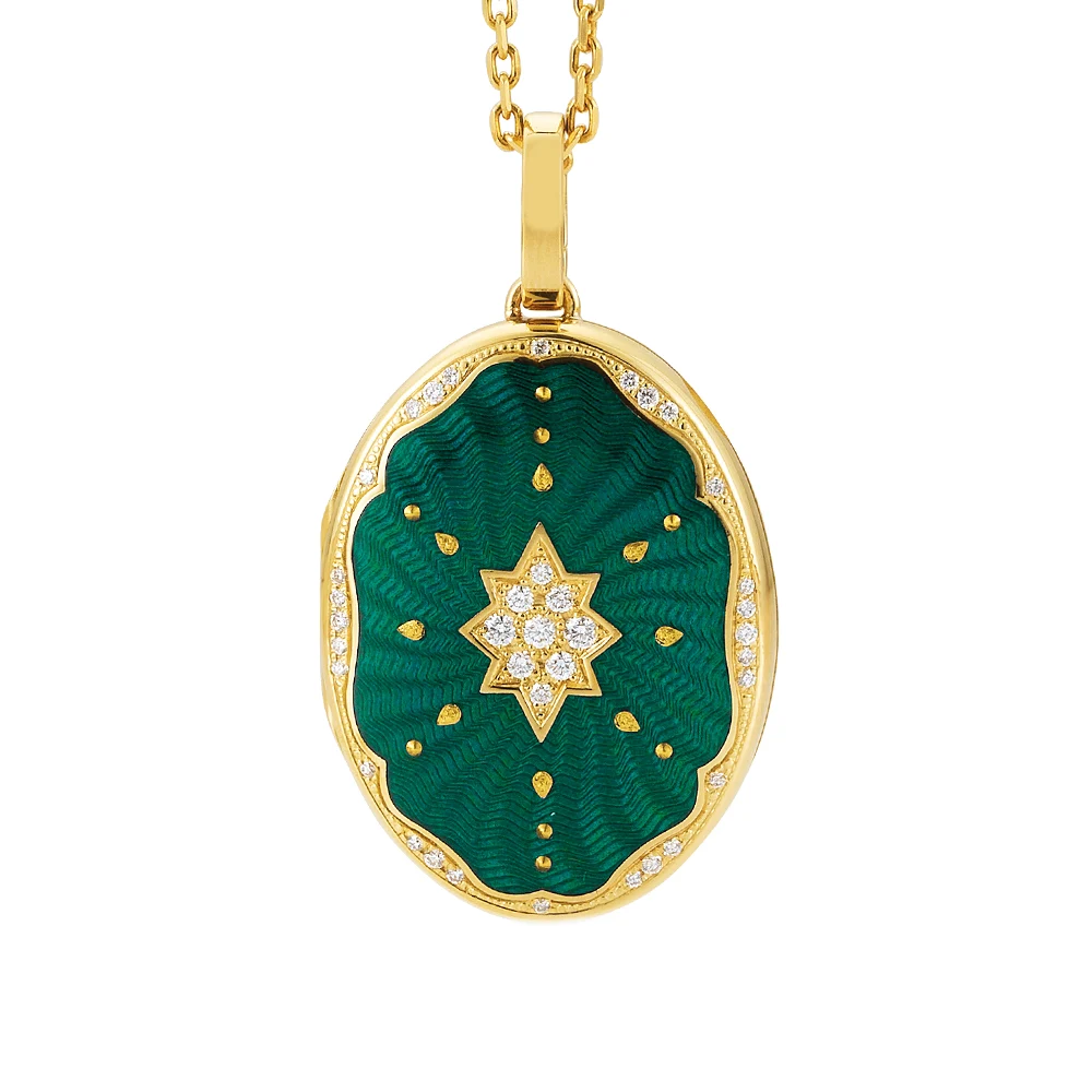 Ovaler Medaillon-Anhänger aus Gelbgold, grün lackiert mit einer vielzahl kleiner goldener Punkte und mit einem Stern aus Brillanten in der Mitte.