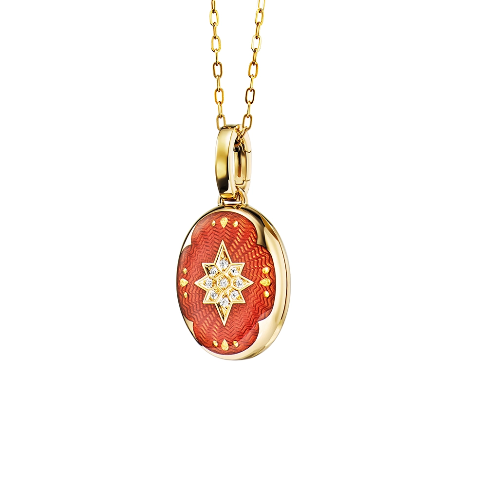 Oval locket pendant in yellow gold, lacquered light red with a multitude of small golden dots and a star made of diamonds in the centre,