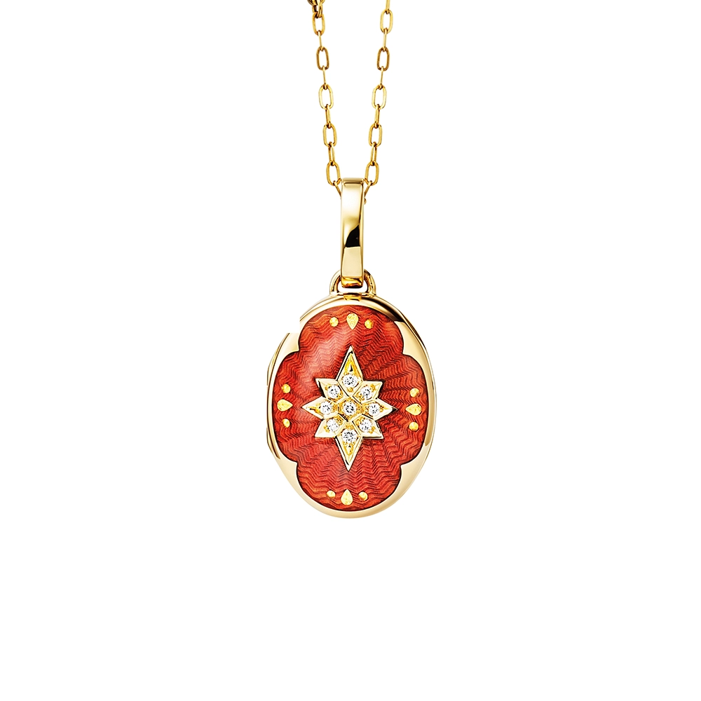 Ovaler Medaillon-Anhänger aus Gelbgold, rot lackiert mit einer vielzahl kleiner goldener Punkte und mit einem Stern aus Brillanten in der Mitte.