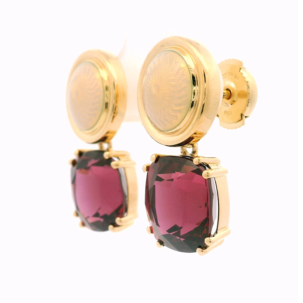 Pair of yellow-gold earrings with red cushion-cut rhodolites in four-claw settings and round white enamel boutons with gold rims.