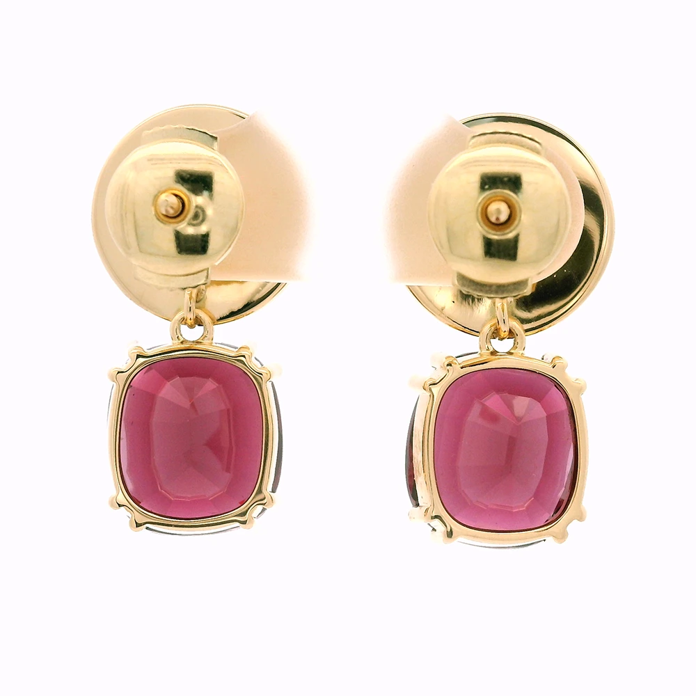 Pair of yellow-gold earrings with red cushion-cut rhodolites in four-claw settings and round white enamel boutons with gold rims.