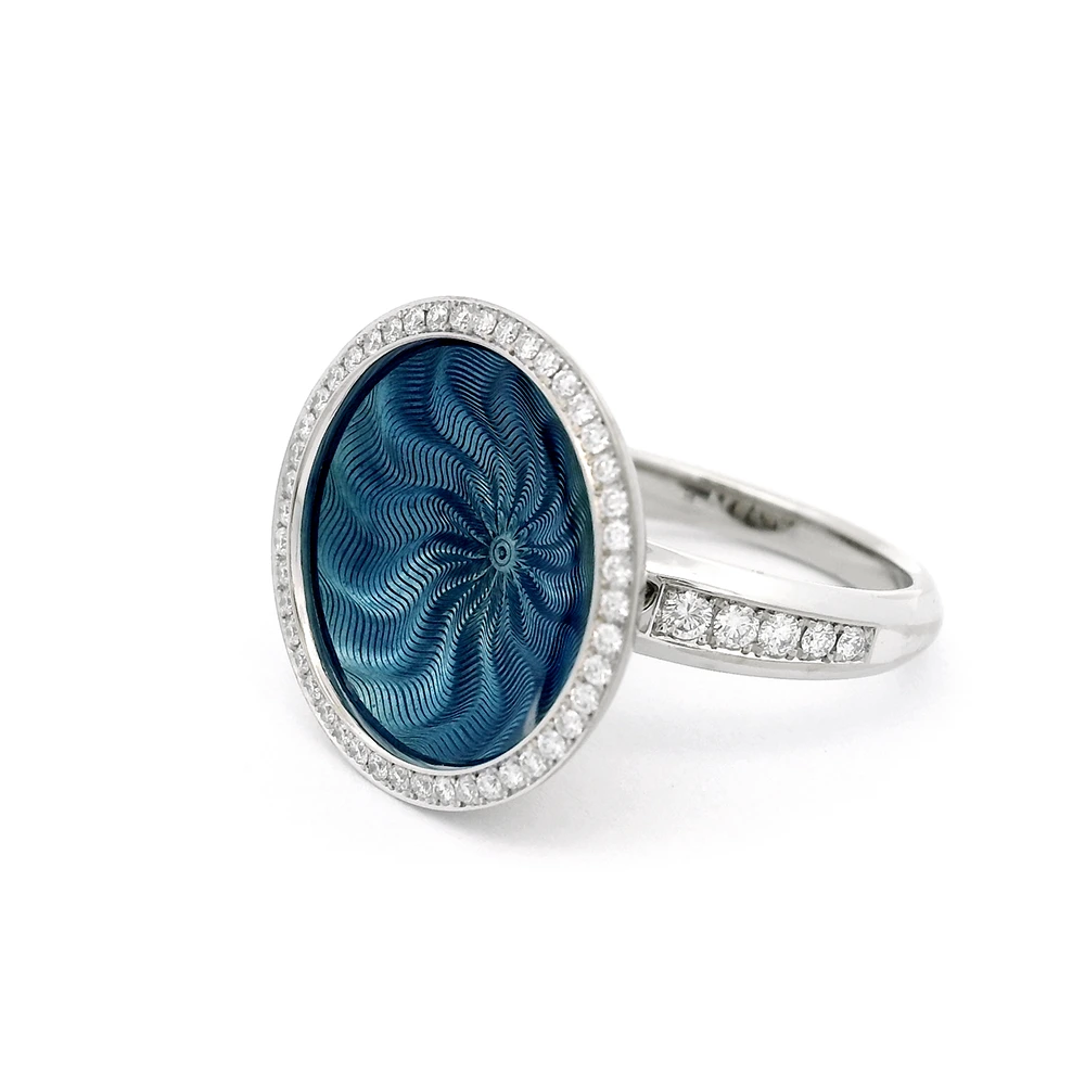 Ring Trance aus Weißgold mit gelbgoldener Basis unter der konkav gewölbten mediumblauer Feueremaille, Windmühlen Guilloché und umlaufendem Brillantkranz, Ringkopf Durchmesser 18,4 mm.