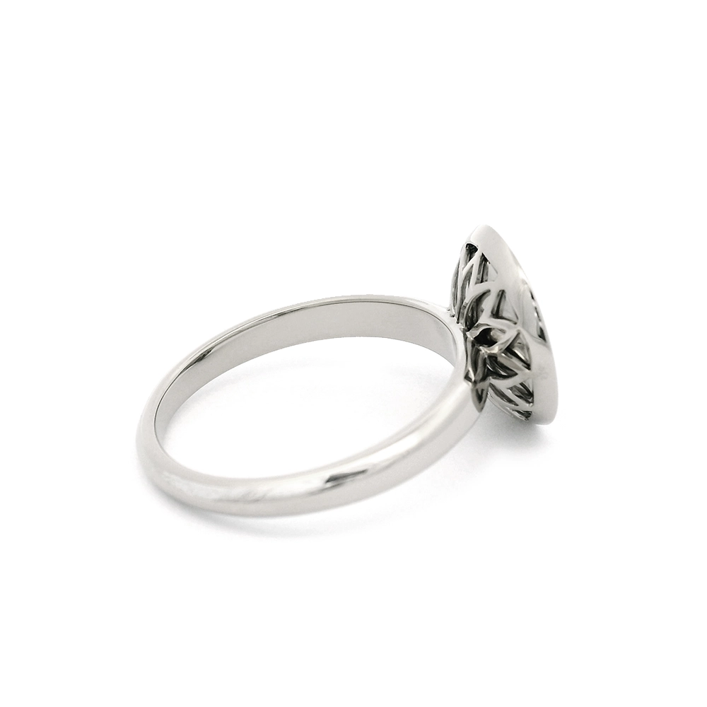 Ring aus Weißgold mit rundem Ringkopf. Der Ringkopf ist konkav gewölbt und mit mediumblauer transluzider Feueremaille versehen, unter der ein feines Windmühlen-Guilloché sichtbar ist. Im Zentrum der Emaillefläche sitzt ein einzelner kleiner Brillant als klarer Lichtpunkt. Die Gestaltung wirkt ruhig, geometrisch und ausgewogen.