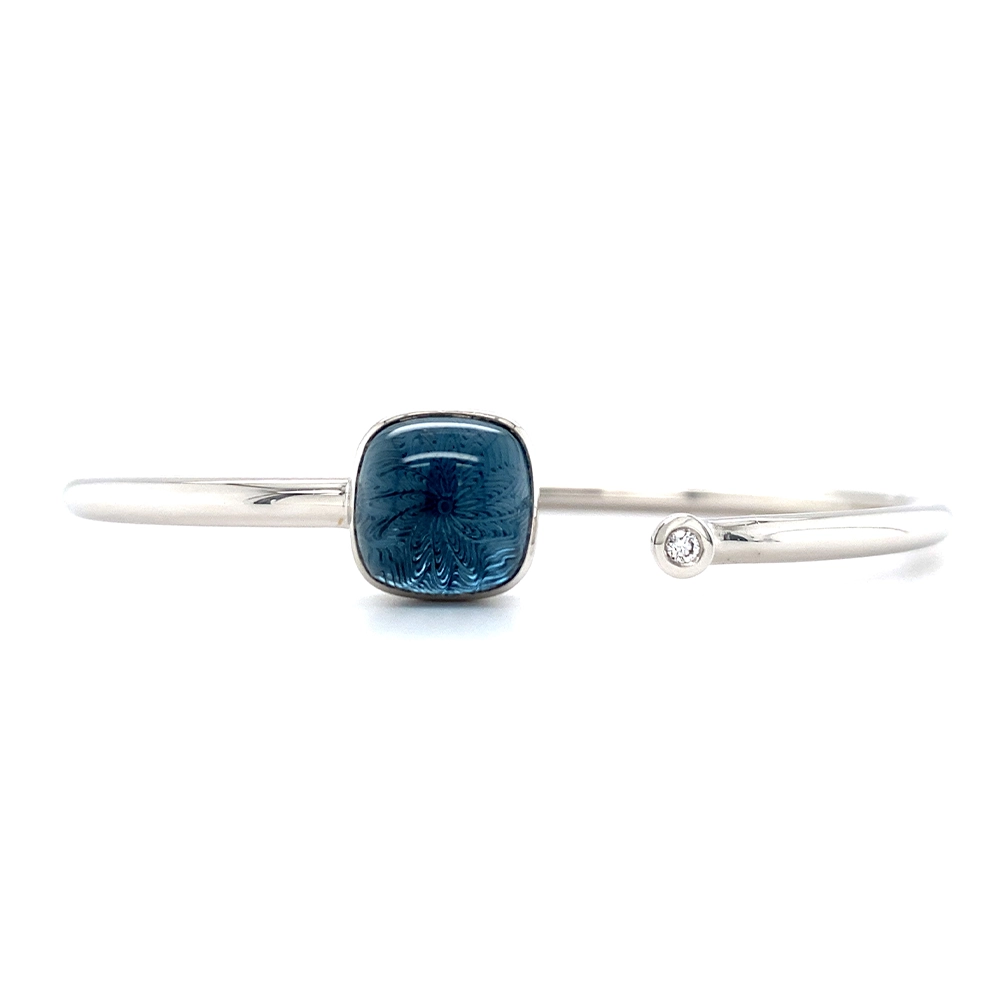 Era Bracelet in white gold with a cushion-cut blue topaz cabochon measuring 10 × 10 mm, a blue translucent gemstone set against a delicate guilloché wave pattern.